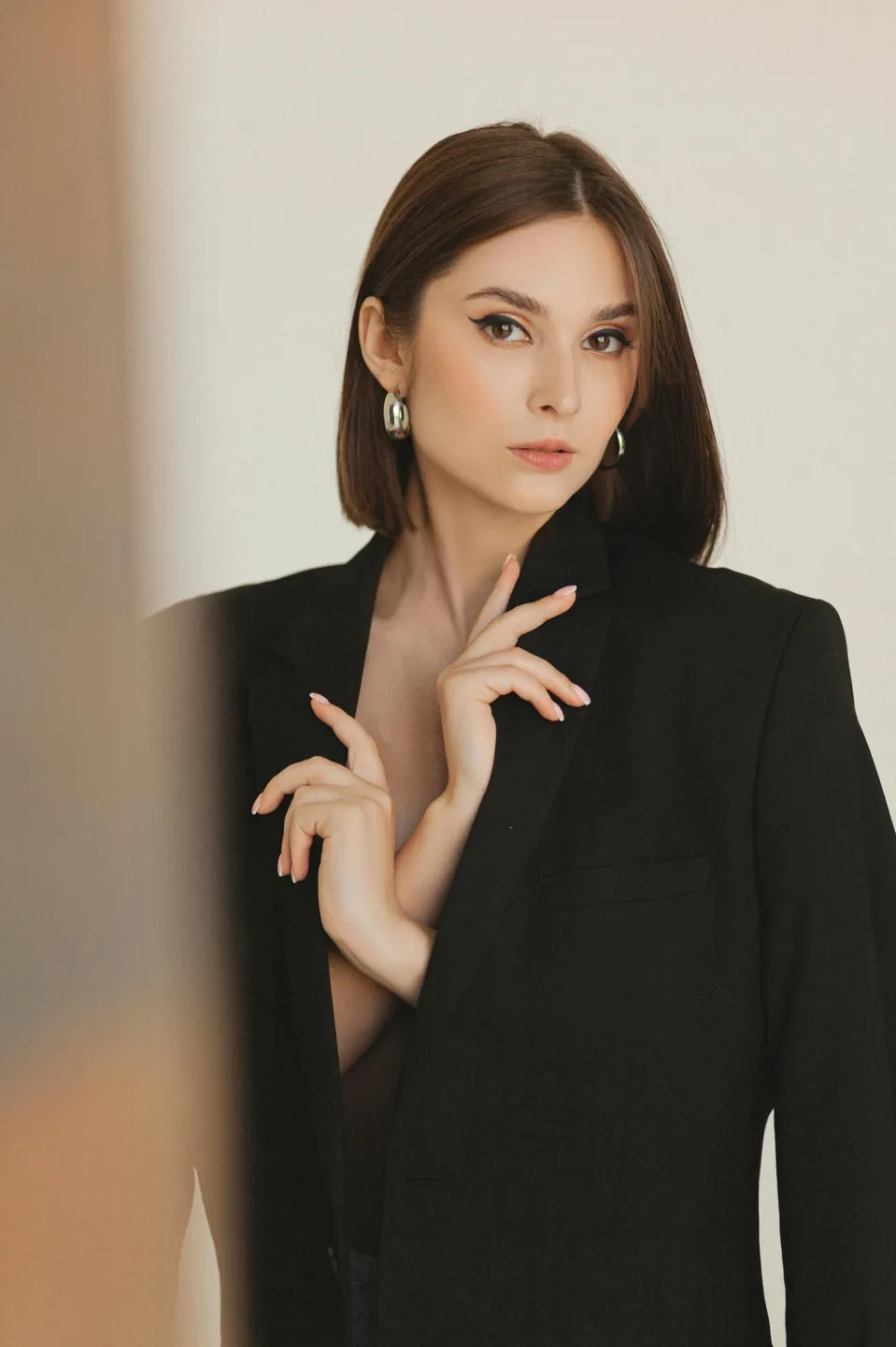 Elegant woman in a black blazer posing gracefully.